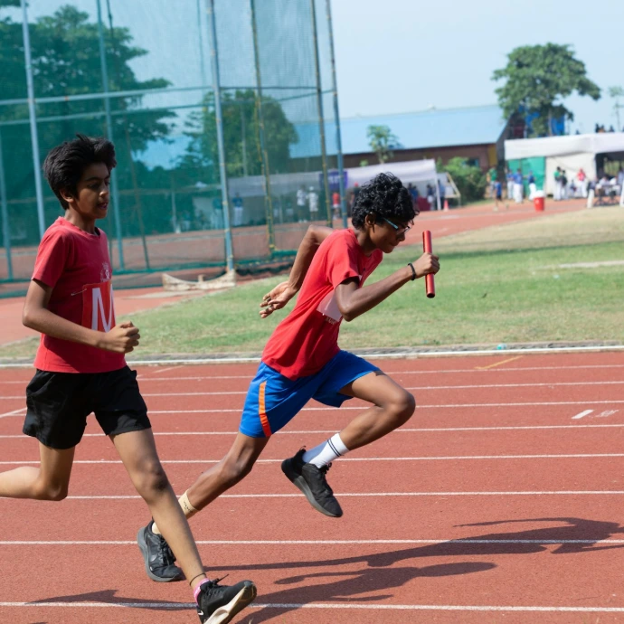 a couple of kids that are running around a track